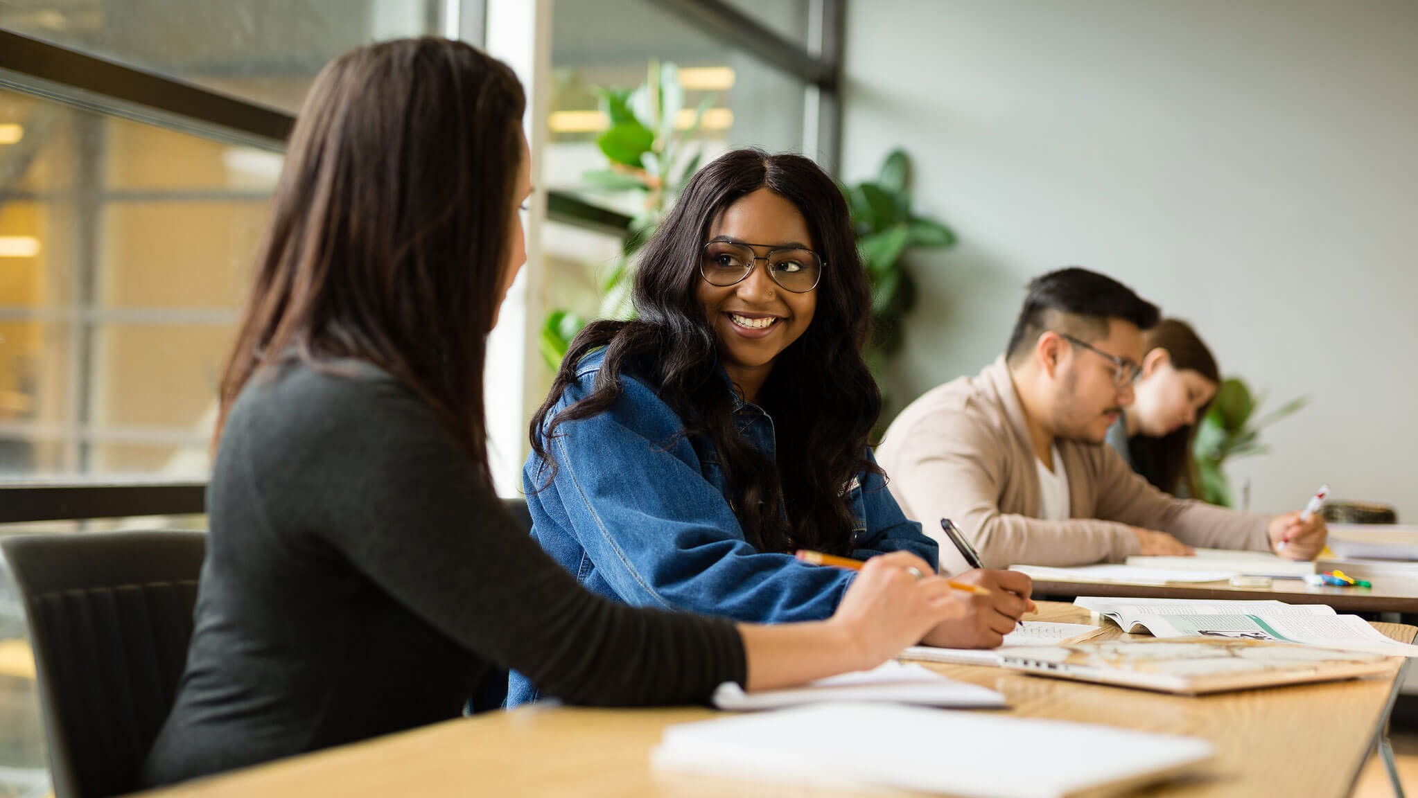 Two students at a desk smiling at each other