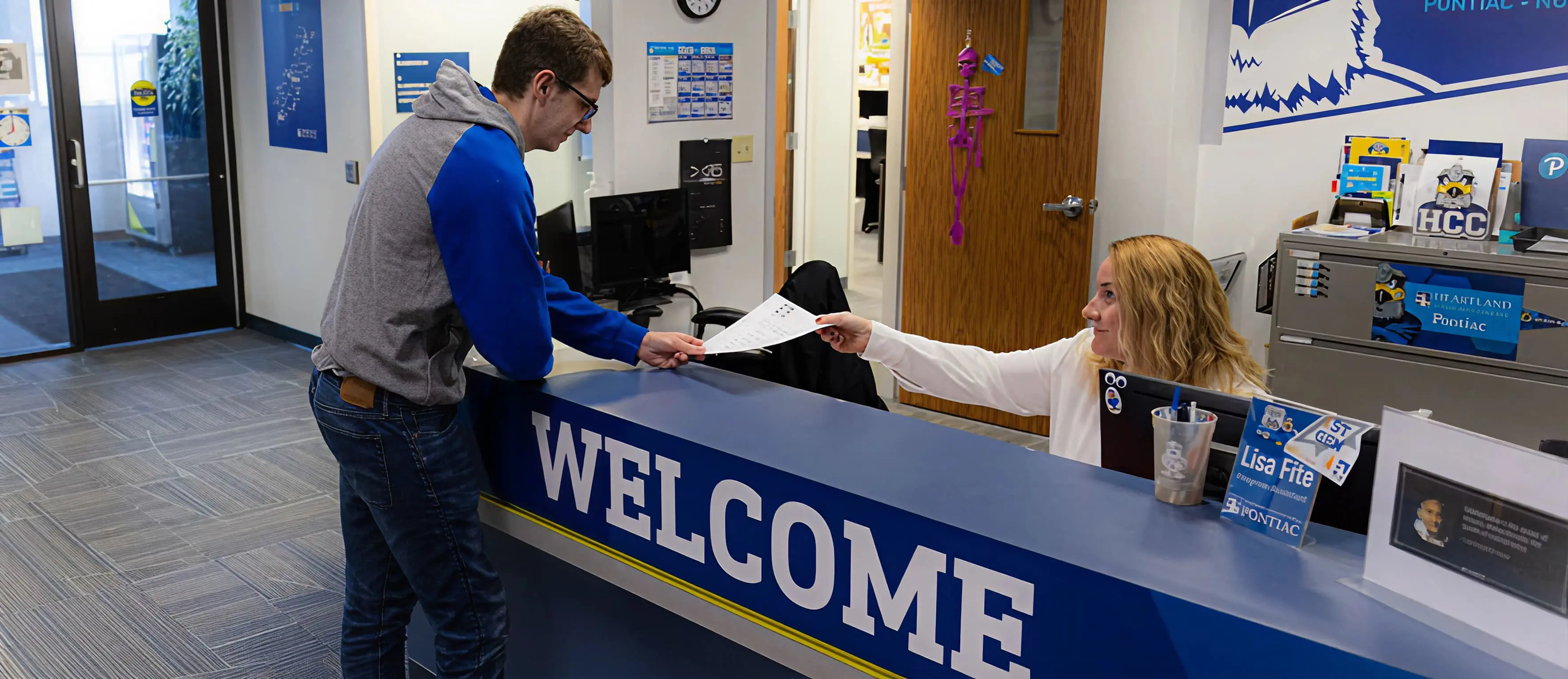 Advisor assisting student at front desk