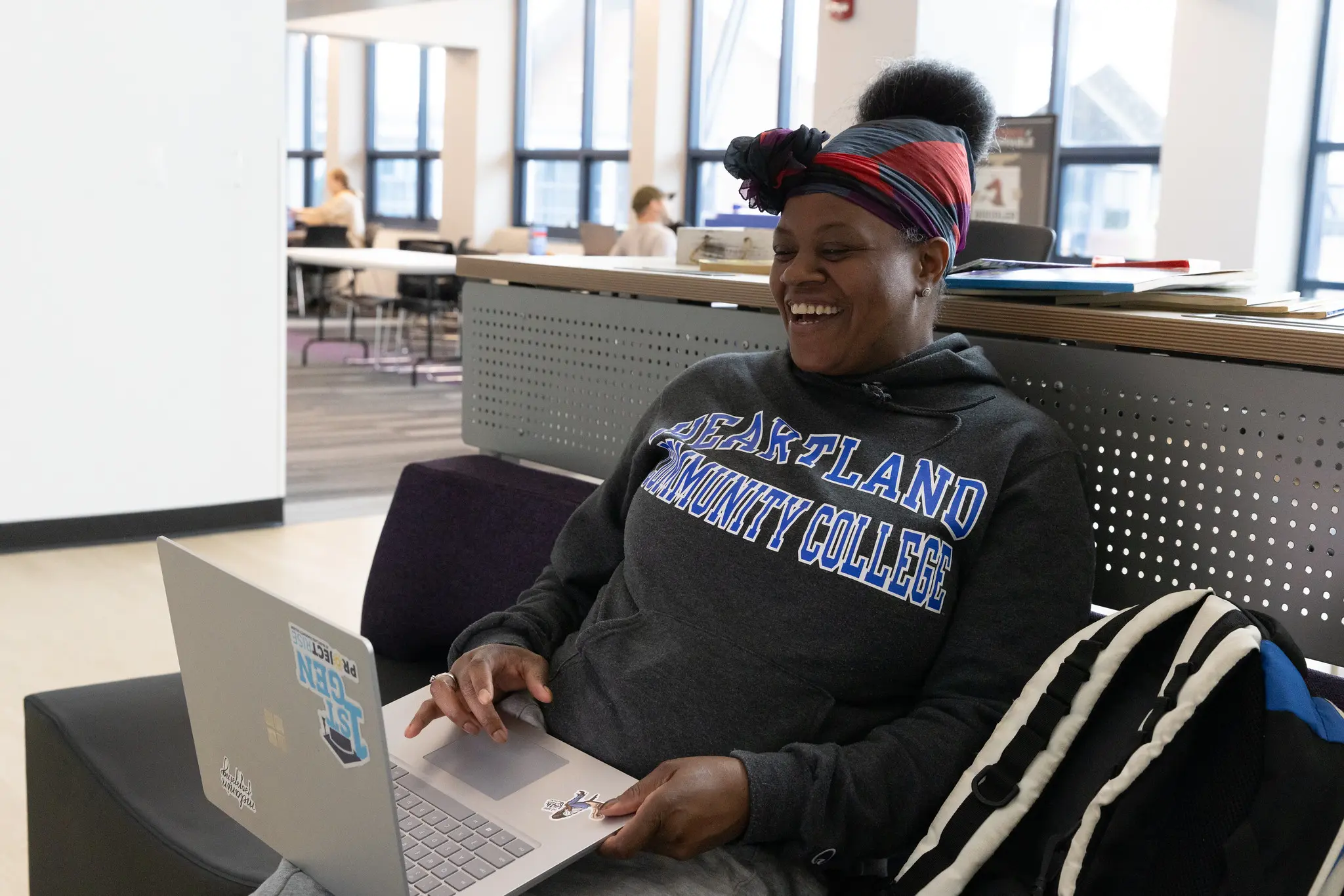 Students smiling in the lobby with a thumbs up