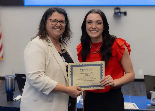 Becky Ropp and Lauren Monk holding awards